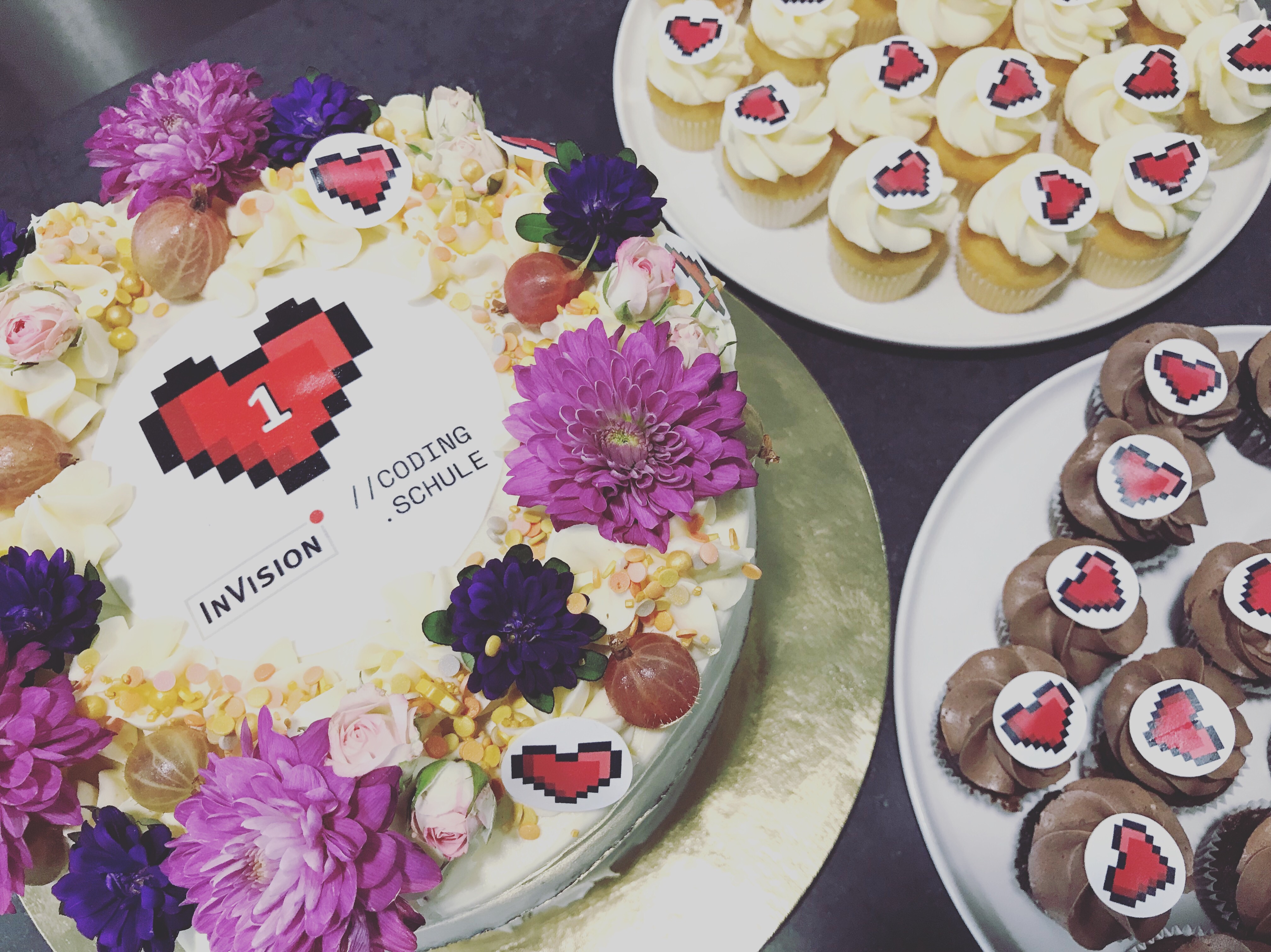 Eine Torte mit Deko und Blumen zum einjährigen Jubiläum der Codingwerkstatt @InVision.